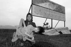 Two_Vietnameses_pose_in_front_of_the_billboard